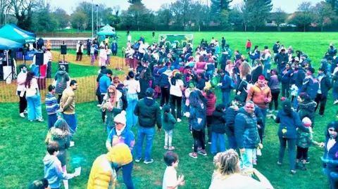Amith Nair A crowd of people during the Holi celebration at Muscliff Park in Bournemouth. It is overcast.