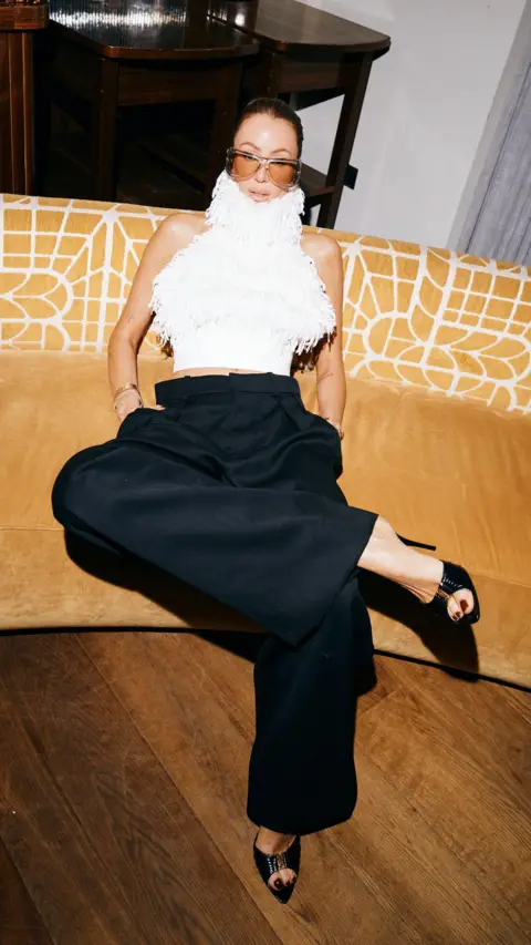 Sofi Adams Picture of Olivia Attwood wearing a white fluffy top and black loose trousers