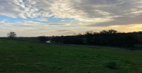 Daniel Mumby A field alongside a road 