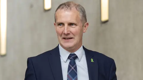 PA Media Michael Matheson in a blue suit at Holyrood