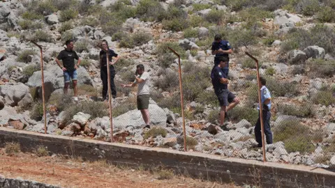 PA Media Members of emergency services on the Greek island of Symi search a rocky area after the disappearance of Dr Michael Mosley