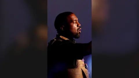 Right side profile of Kanye West mid-speech.