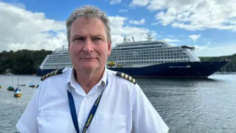 Fowey harbourmaster Captain Paul Thomas with a cruise ship in the background