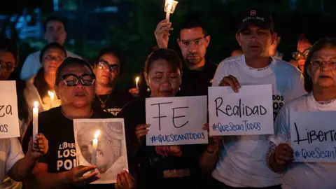 Rows of people hold a vigil calling for the release of prisoners in Venezuela 
