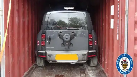West Midlands Police A police photograph shows a grey SUV in a red metal container. The licence plate has been blurred out.