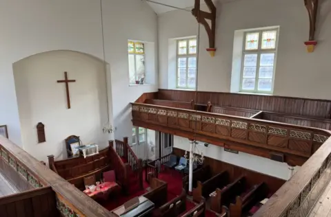 Paul Fosh Auctions A wooden balcony area with a cross on the chapel wall 