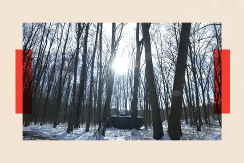 A tank sits among trees in a snow covered forest in Sumy