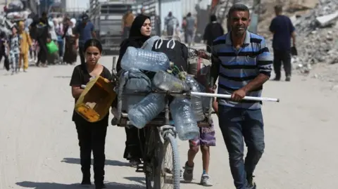Palestinians carrying supplies on a road in Gaza
