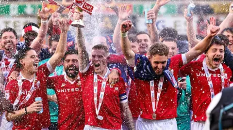Wrexham players celebrate promotion into the Championship