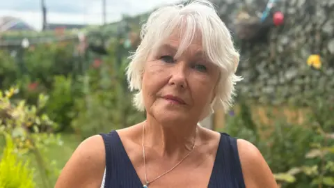 A woman with light hair looking at the camera