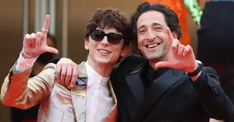 Getty Images French-Us actor Timothee Chalamet (L) US actor Adrien Brody pose as they arrive for the screening of the film "The French Dispatch" at the 74th edition of the Cannes Film Festival in Cannes, southern France, on July 12, 2021