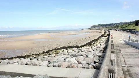 Geograph/Jeff Buck View of Colwyn Bay beach and promenade with rocks and walkway in concrete 