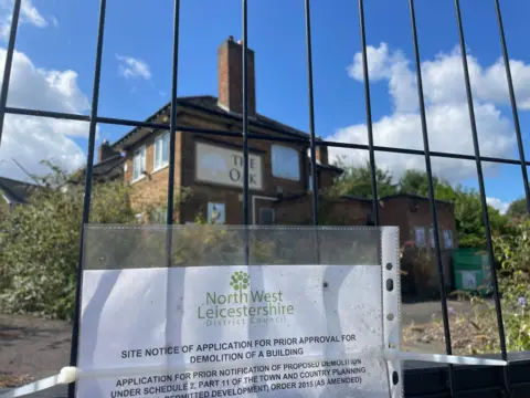 A planning noticed posted on fencing around a derelict pub