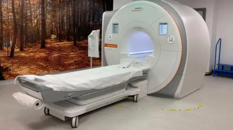 The images shows a white MRI scanner used in hospitals to monitor for tumours.