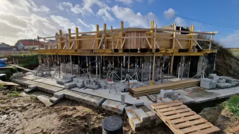 A7 Architecture wooden scaffolding surrounding a concrete bunker 