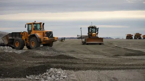 Camiones y excavadoras en la pista del aeropuerto de Nuuk.