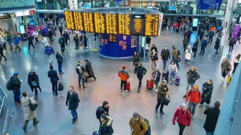 Getty Images FILE IMAGE - Commuters arrive at Manchester Piccadilly railway station in Manchester, UK, on Thursday, Dec 8, 2022. 