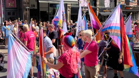 People with rainbow flags celebrating Notts Pride in Nottingham city centre on 25 July.