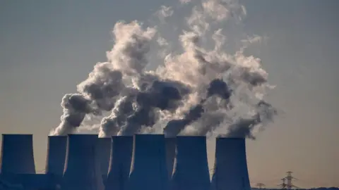Cooling towers release water vapor at the Jaenschwalde lignite-fired power station in Jaenschwalde, Germany