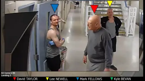 CPS A CCTV image from inside the prison which shows three inmates standing outside a cell smiling 
