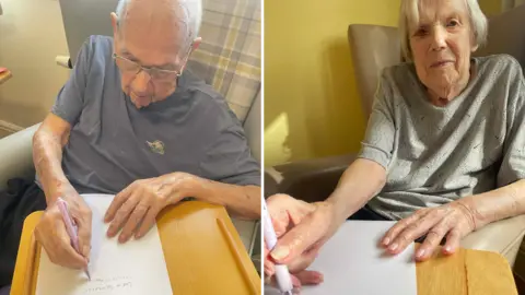 Orchard House Care Home An image of two people writing letters are side by side. Harold is on the left and has short grey hair and is wearing a grey T-shirt. On the left is Dorothy who is wearing a green T-shirt and has short grey hair.