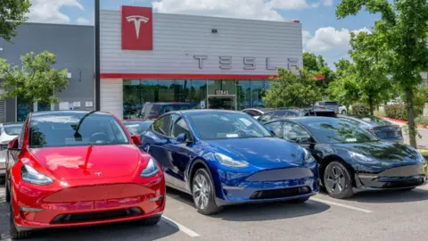 Getty Images Tesla Model Y vehicles sit on the lot for sale at a Tesla car dealership on May 31, 2023 in Austin, Texas. 