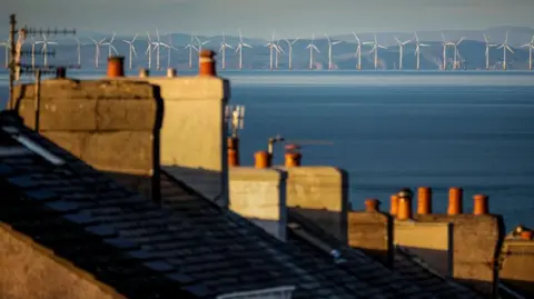 An aerial image of the Robin Rigg off-shore wind farm in the distance, captured from the roofs of homes in Whitehaven