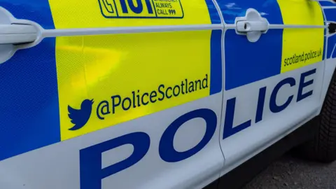 A police car with bright yellow and blue colours