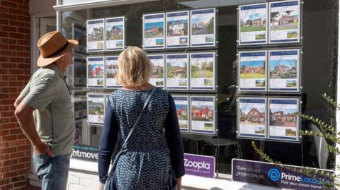 People looking at estate agent's window
