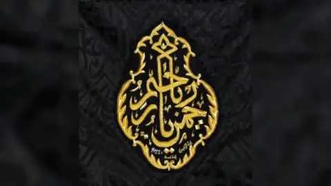 Gold thread of an Islamic, Arabic design on black cloth