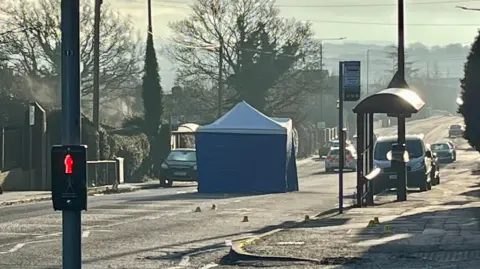 A photograph of the crime investigation scene with a police tent that has been installed in the middle of Heanor Road