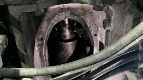 HSE A close up of the hydraulic ram in the machine that caused the accident. It is a large, cylindrical piece of metal with different sections