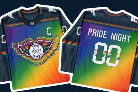 Fife Flyers Hockey jerseys with dark sleeves and a rainbow gradient on the front. On the left you can see the front of the jersey has the Fife Flyers logo in rainbow colours, and the right shows the back of the jersey with "PRIDE NIGHT 00" written on it 