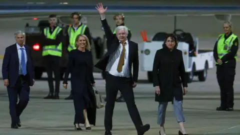 Reuters Julian Assange waving on the tarmac at Canberra airport
