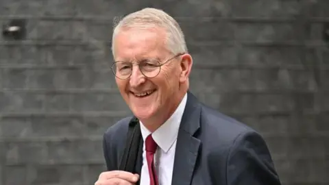 Getty Images Hilary Benn walking and smiling looking at the camera