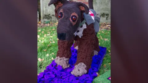 Mandy Wright Photography A brown knitted dog decorated with brown and purple flowers 