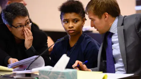 Getty Images Chrystul Kizer sits with her lawyers during a hearing in the Kenosha County Courthouse on 15 November 2019