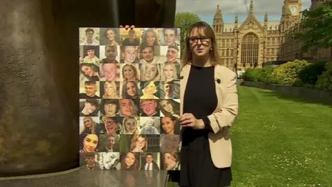 BBC Crystal Owen holding a photo montage of young road crash victims outside parliament