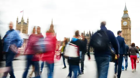People walking past the Houses of Parliament