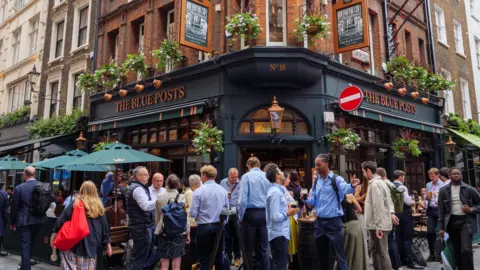 People standing and drinking outside The Blue Posts pub