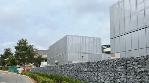BBC A large grey building at the site of the Princess Elizabeth Hospital. 