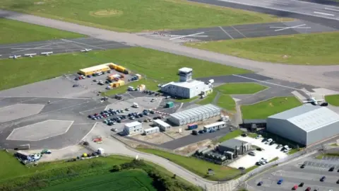 Newquay Airport from above with the runway and terminal buildings and hangars   