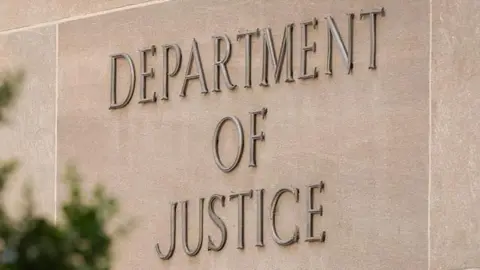  A sign marks the location of the U.S. Department of Justice (DOJ) headquarters building