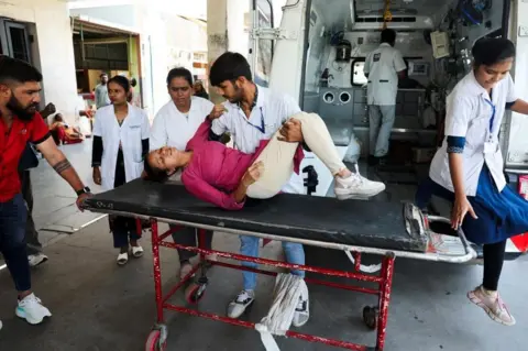 Reuters riyanshi Fakirbhai Patel, 20, who according to medical staff suffers from heat exhaustion, is helped by medical staff at the hospital during a heatwave in Ahmedabad, India, May 24, 2024. REUTERS/Amit Dave
