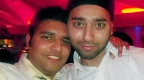 Bhadur Singh Rathor A slightly blurry photo of two young men smiling in a nightclub with their arms round each other