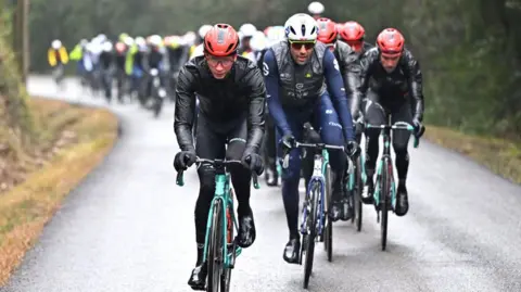 Riders cycling in wet weather condition during the Etoile de Besseges road cycling race 