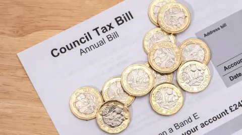 Getty Images One pound coins on a council tax statement 