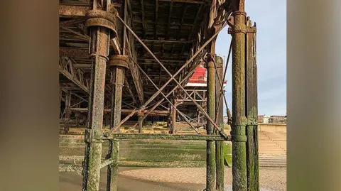 Structure underneath Blackpool's Central Pier while the tide is out. It shows one of the cross beams has snapped.