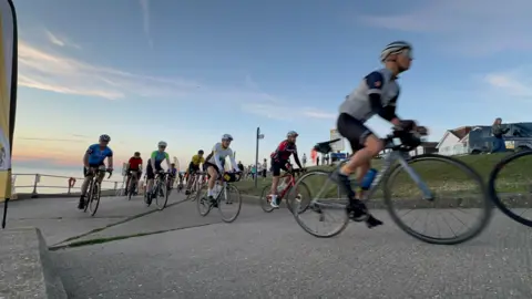 Cyclists riding by the coast.