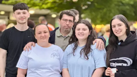 Five relatives of Mario Fassoli - three women and two men - look into the camera after completing the walk.